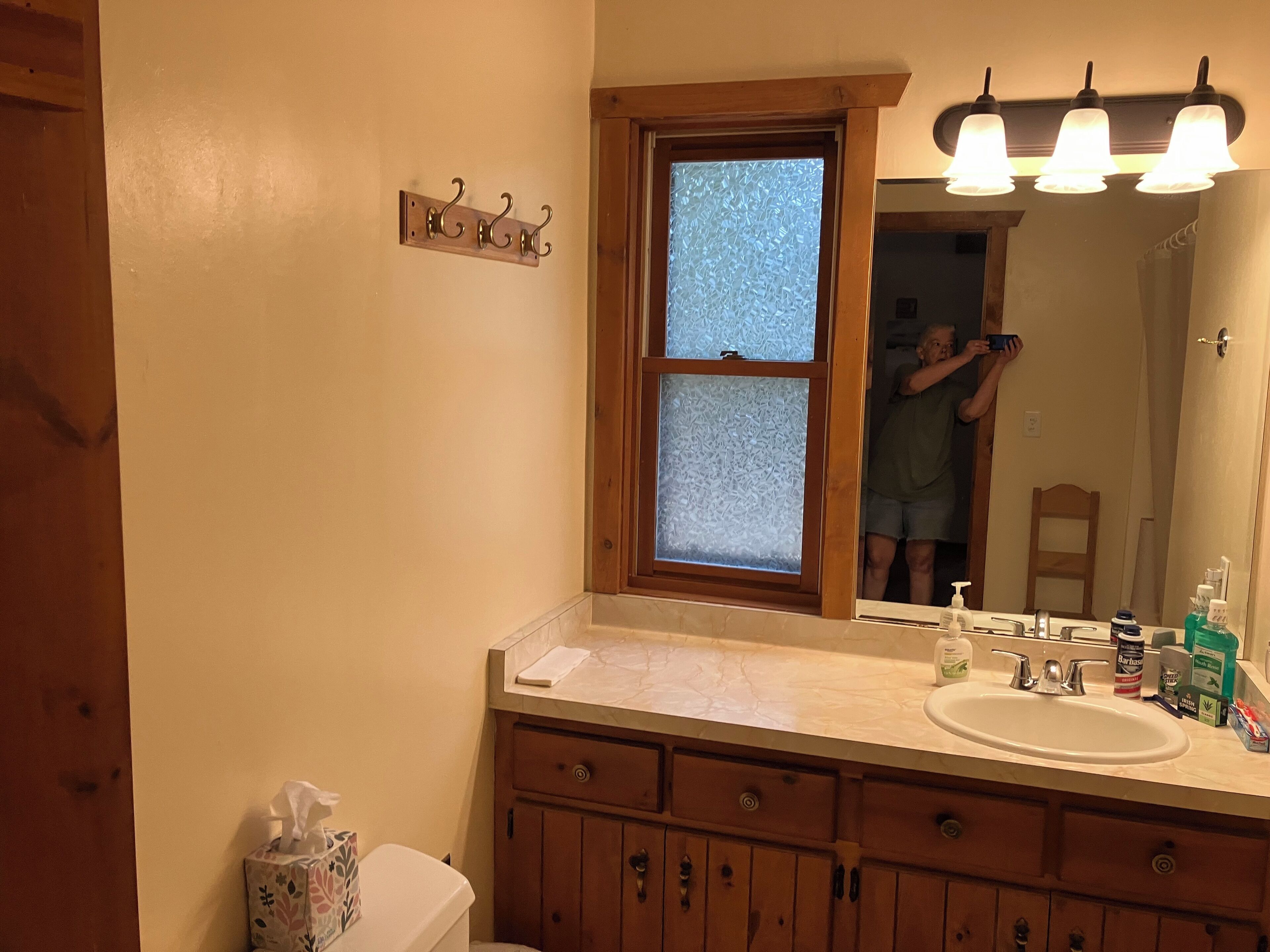 Une salle de bain avec un meuble-lavabo en bois, un évier et un miroir.