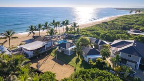 A coastal residential area with houses, a swimming pool, and a beach.