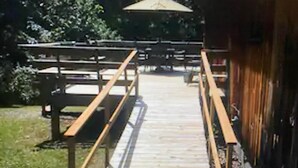 A wooden deck leading to a building with a covered area.
