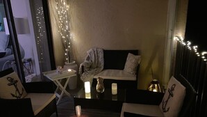 Un'accogliente area salotto con divano e poltrone, un tavolino con candele e luci decorative.