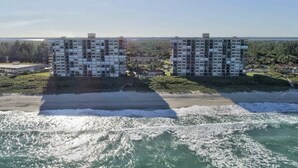 Due grattacieli con una spiaggia e l'oceano sullo sfondo.
