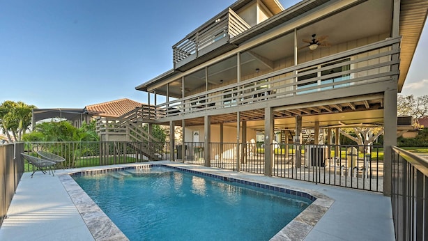 Uma casa moderna com piscina, varanda coberta e varanda de dois andares.