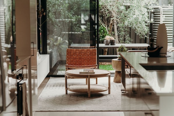 A modern kitchen with a round table, a wicker chair, and a view of the outdoors. - Light-filled & stylish. Central Location.✨ (Merewether)