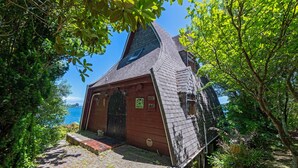 A small, rustic cabin with a steeply pitched roof, a wooden door, and a small window.