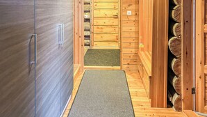 Un sauna avec des murs en bois et un banc.