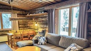 L’intérieur d’un chalet confortable, avec un canapé, une table en bois et des chaises.