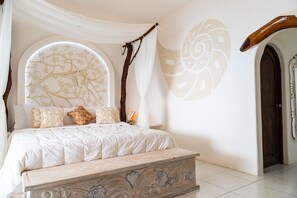 Une chambre à coucher avec un grand lit, un baldaquin et un mur décoratif.