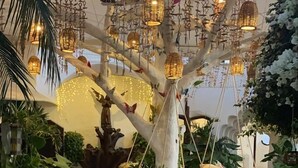 A treehouse with hanging lanterns and a swing set.