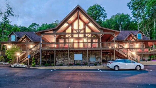 A large lodge with a prominent central tower, multiple balconies, and a spacious entrance area.
