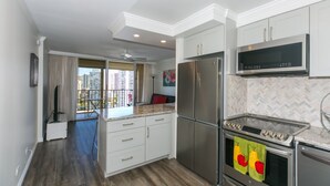 Een moderne keuken met roestvrijstalen apparatuur, een backsplash met een mozaïekpatroon en uitzicht op de stad.