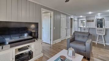 A living room with a gray sofa, a gray armchair, a coffee table, and a fireplace.