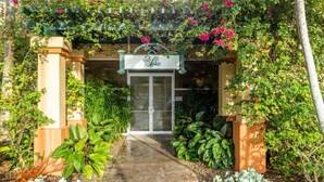 A hotel entrance with a sign reading "Spa" under a green archway. - Pompano Beach | Group Golf Vacation | Pool + Golf | 4BR Sleeps 12 (Pompano Beach)