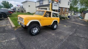 A yellow SUV parked in a parking lot with a 'Welcome' sign in the background. - Rockwood Resort Motel (Lake Ozark)