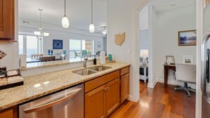 A modern kitchen with granite countertops, stainless steel appliances, and pendant lighting. - Lakefront Condo, Balcony, Pool, Beach, Wineries (Geneva)