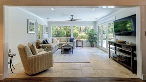 A spacious living room with a sectional sofa, a coffee table, and a TV on a wooden stand. - Sunset Rentals | South Live Oak 25 (Hilton Head Island)