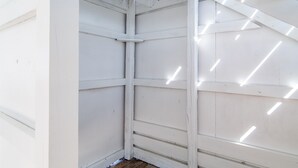 A corner of a room with white walls and a wooden floor. - Private lagoon beach, Gulf beach steps away (Gulf Shores)