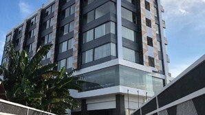 Um hotel moderno de vários andares com fachada geométrica e céu claro.