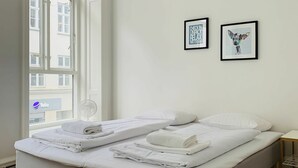 A modern hotel room with a large bed, a small bedside table, and two framed artworks on the wall. - City Apartment in Copenhagen with 2 bedrooms sleeps 6 (Copenhagen)