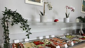 A buffet with various food options, including meats, cheeses, and fruits, displayed in a glass case with labels. - Mirage City Hotel Stuttgart (Stuttgart)