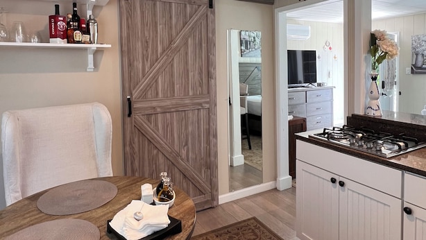 Une cuisine équipée d’une cuisinière à gaz, d’une table à manger en bois et d’une porte coulissante de style rustique.