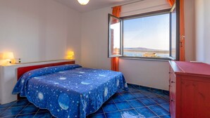 A bedroom with a bed, a window with curtains, a ceiling fan, and a dresser. - Holiday Home "Pergola 714" Steps from the Beach with Sea View and Balcony (STINTINO)