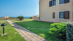 Un bâtiment moderne doté d’un chemin pavé, d’un petit jardin et offrant une vue sur la mer.