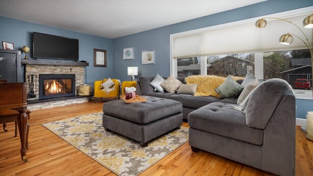 A living room with a fireplace, a sofa set, a coffee table, and a TV.