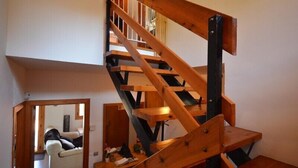 Una escalera de madera con barandilla y rellano.