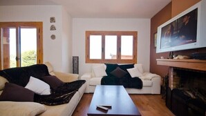 Una sala de estar con dos sofás, una mesita de centro, chimenea y televisor.