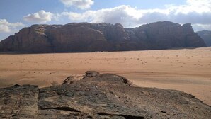 A desert landscape with prominent rock formations and a clear sky.