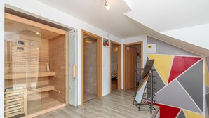 A modern interior with a wooden floor, glass doors, and a colorful geometric wall design. - Pool & Sauna Countryside Retreat Klara (Velika Gorica)