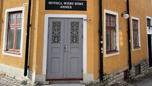 Un bâtiment sur lequel on peut lire l’inscription « HOTELL WISBY BÖRS ANNEX ».