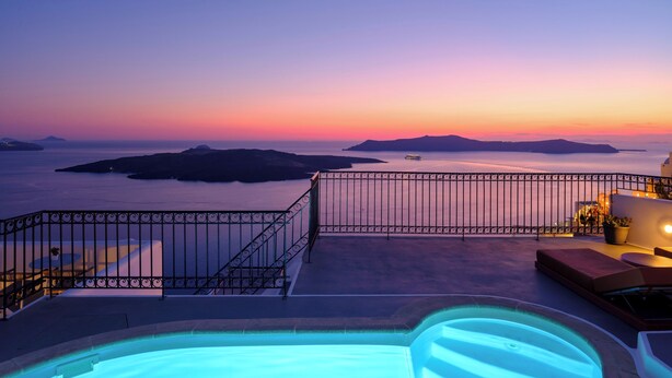 Una piscina sul tetto con vista sul mare e sulle isole al tramonto.