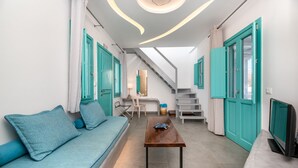 Un intérieur moderne avec des portes de couleur turquoise, un canapé, une table basse et un escalier.
