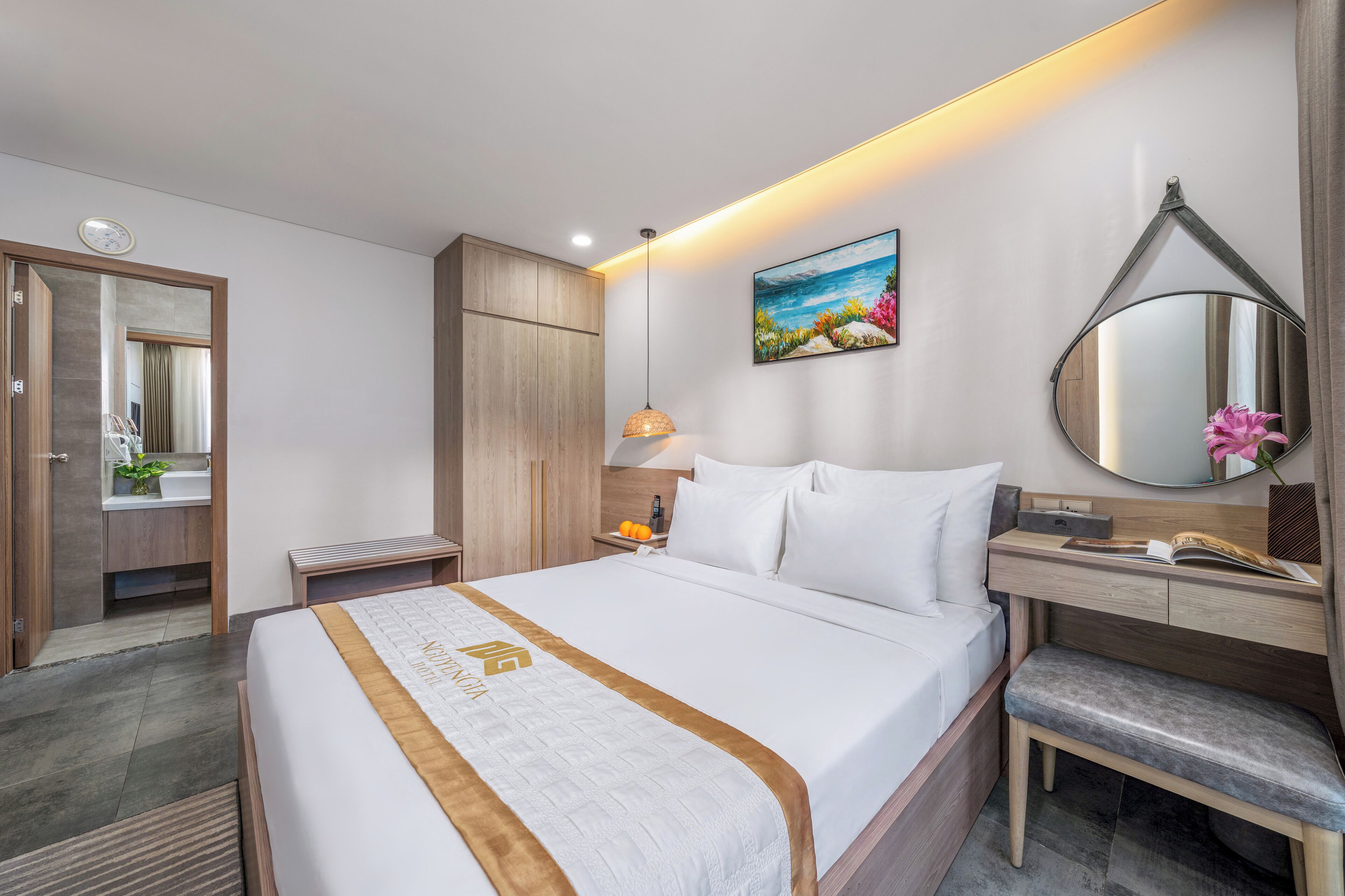 Ein Hotelzimmer mit Bett, Nachttisch, Spiegel und einem Gemälde an der Wand.