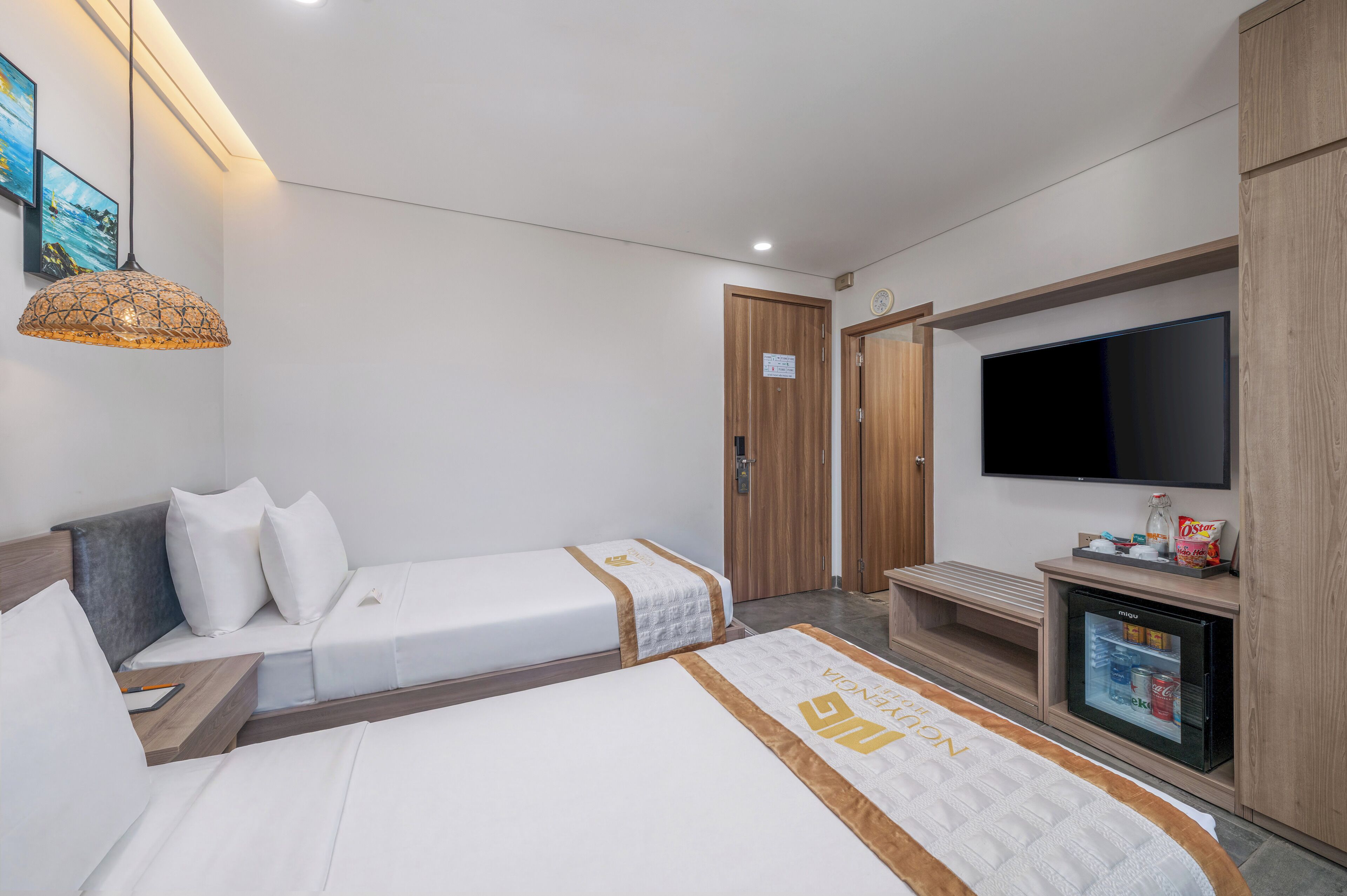 Habitación de hotel con cama, televisor, minibar y armario.