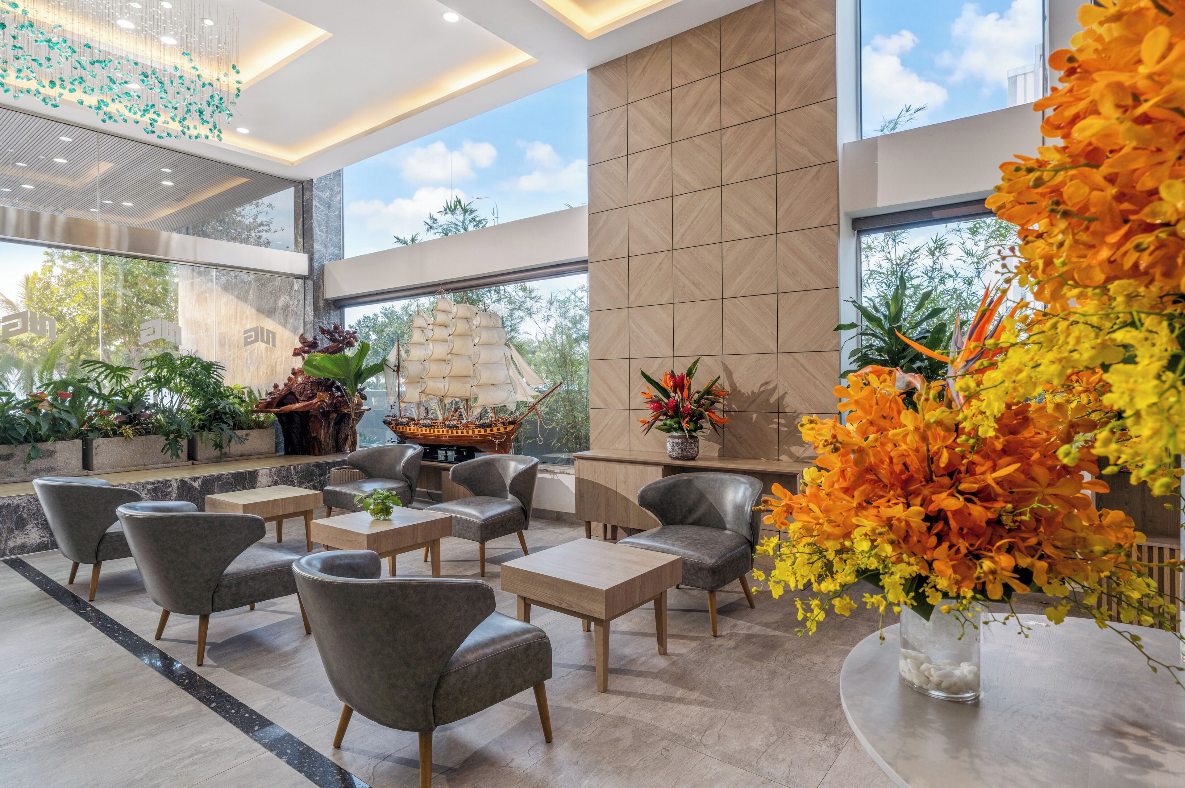 Eine moderne Lobby mit Sitzgelegenheiten, einem Schiffsmodell und großen Fenstern.