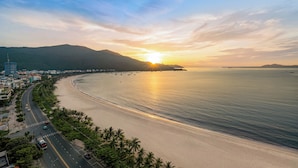 A coastal road with a beach and a mountain in the background. - Nguyen Gia Hotel (Da Nang)