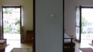 Una habitación con puerta corrediza de vidrio que da a un balcón, una mesita y una silla.