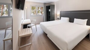 Una habitación de hotel moderna con una cama grande, un escritorio y una silla.