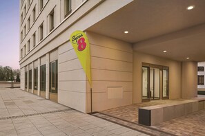 A hotel entrance with a large sign, a glass door, and a tiled pavement. - Super 8 by Wyndham Chemnitz (Chemnitz)