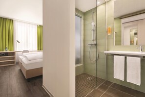 A hotel room with a bed, a bedside table, a lamp, and a window with curtains. - Super 8 by Wyndham Chemnitz (Chemnitz)