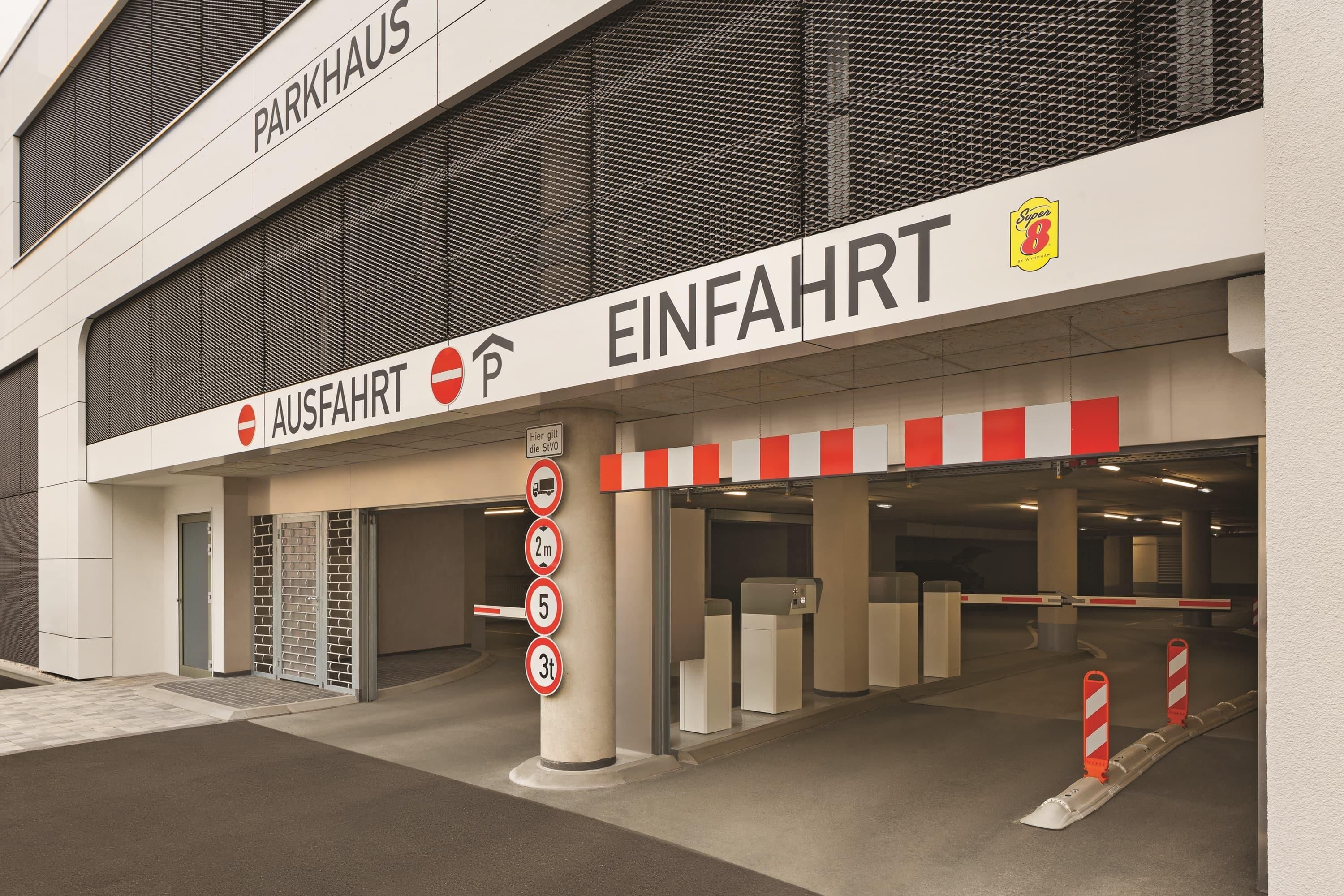 Einfahrt zu einer Parkgarage mit Schildern für 'PARKHAUS' und 'EINFÄHRT'.