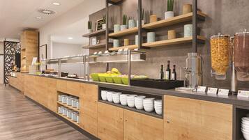 Um balcão de café da manhã moderno com diversas opções de alimentos, incluindo cereais e bebidas, e uma seleção de objetos decorativos em prateleiras.
