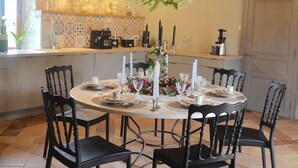 A round dining table with six chairs, candles, and a floral centerpiece. - charming cottage at the gates of Issigeac (Montaut D'issigeac)