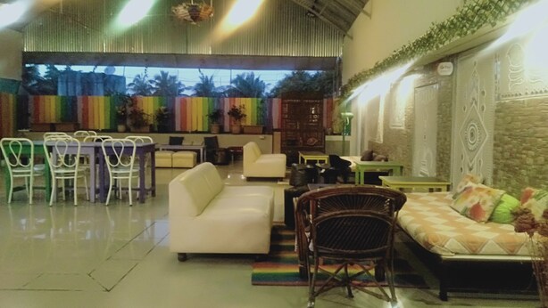 A spacious indoor area with a high ceiling, a seating area with a sofa and chairs, and a colorful wall decoration. - Choice Service Apartment (Pune)
