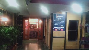 A hallway leading to a restaurant with a signboard listing specialties like flavored soda, mocktails, and burgers. - Choice Service Apartment (Pune)