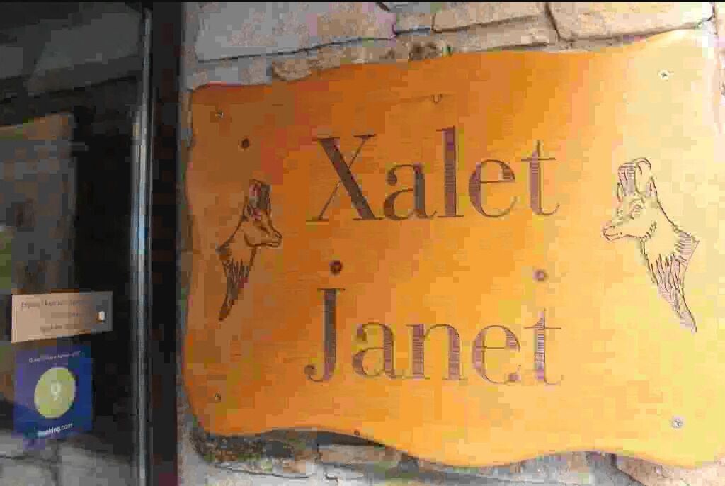 Une enseigne portant le nom « Xalet Janet » et représentant deux chiens.