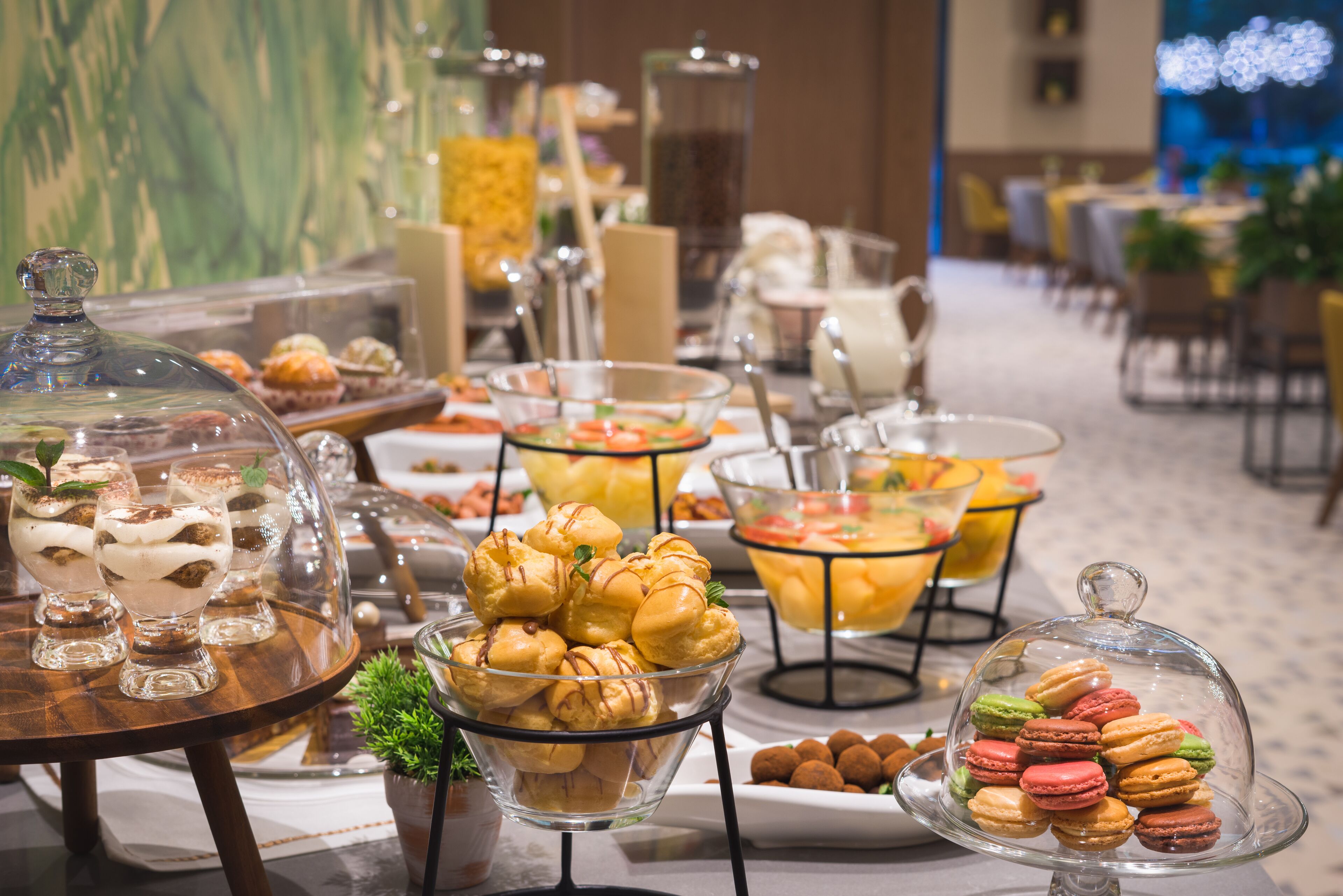 Ein Buffet mit verschiedenen Speisen, darunter Gebäck, Desserts und Früchte.