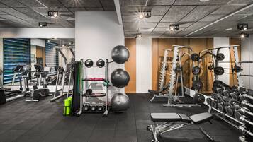 Una palestra con diverse attrezzature per esercizi, tapis roulant e macchinari per pesi.